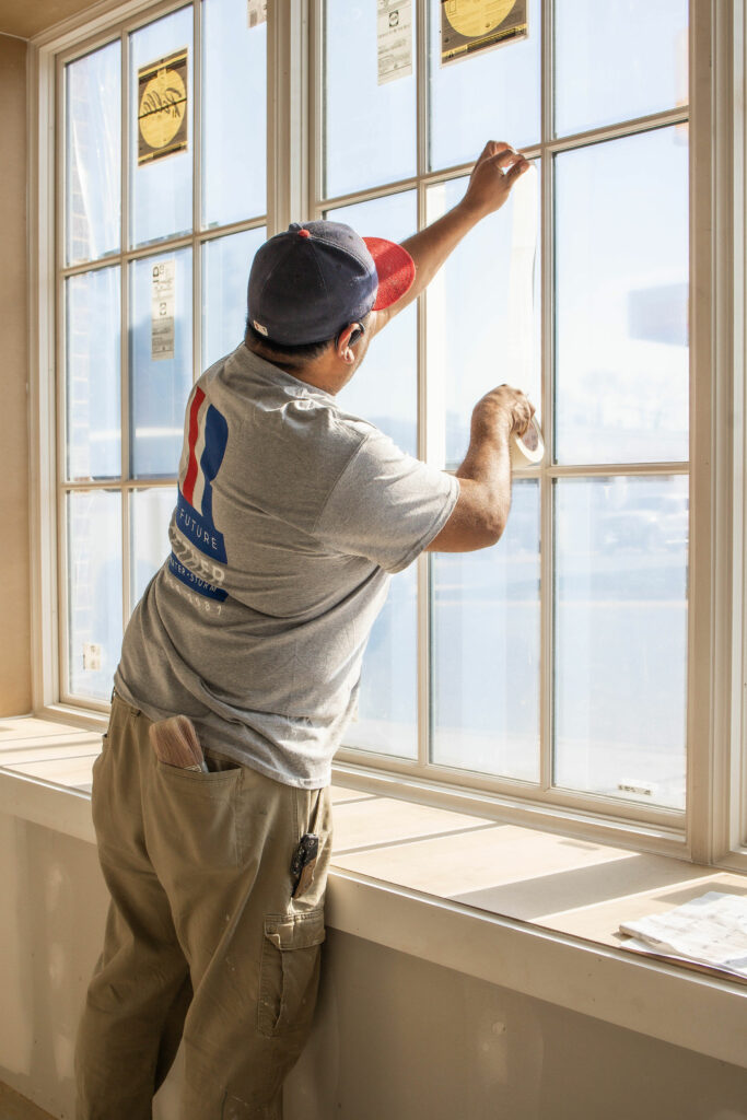 Man fixing window as part of storm damage repair process